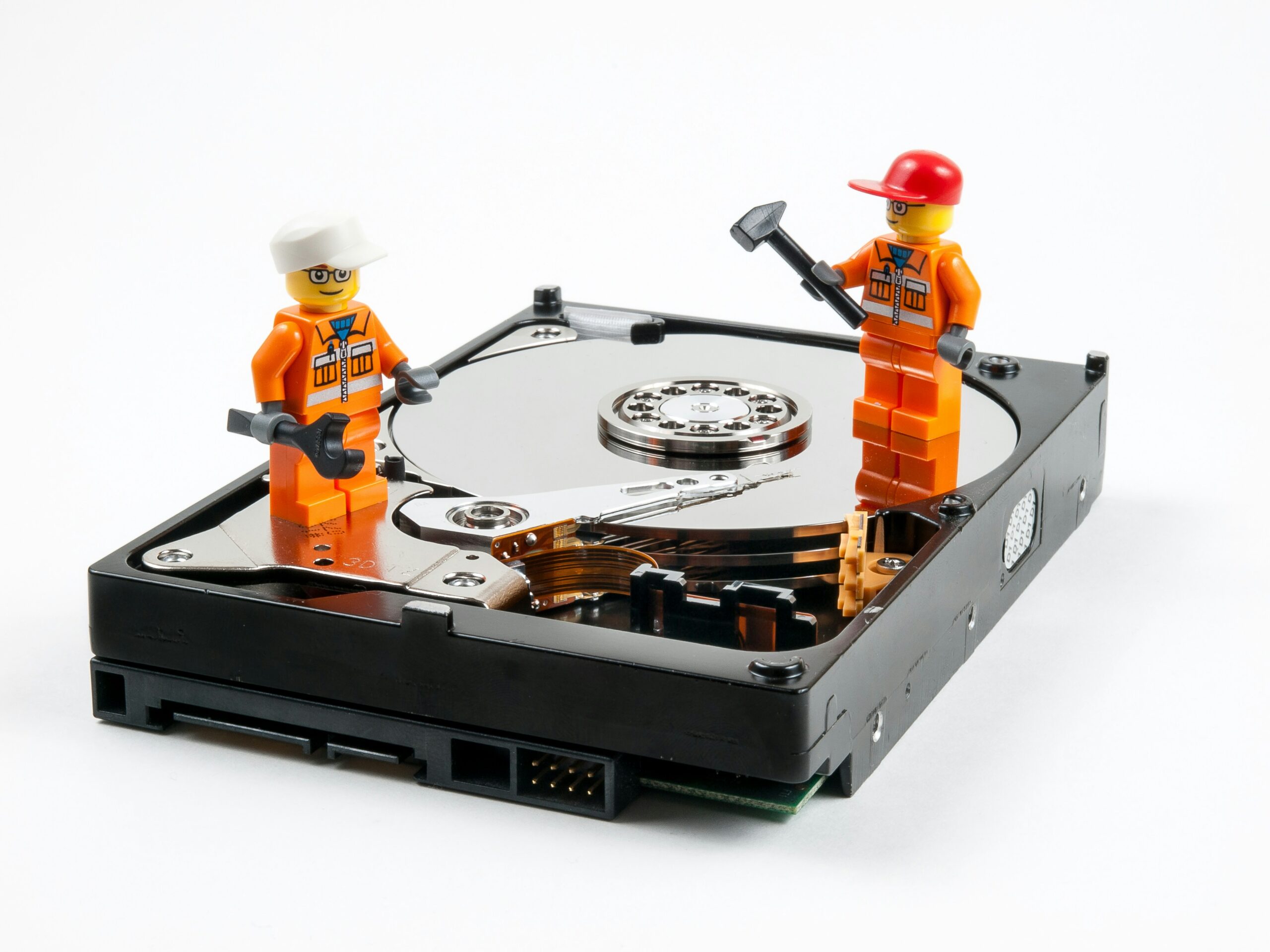 A couple of legos standing next to a hard drive